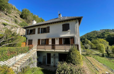 Ensemble immobilier de deux maisons, garages et terrain en bordure de rivière..